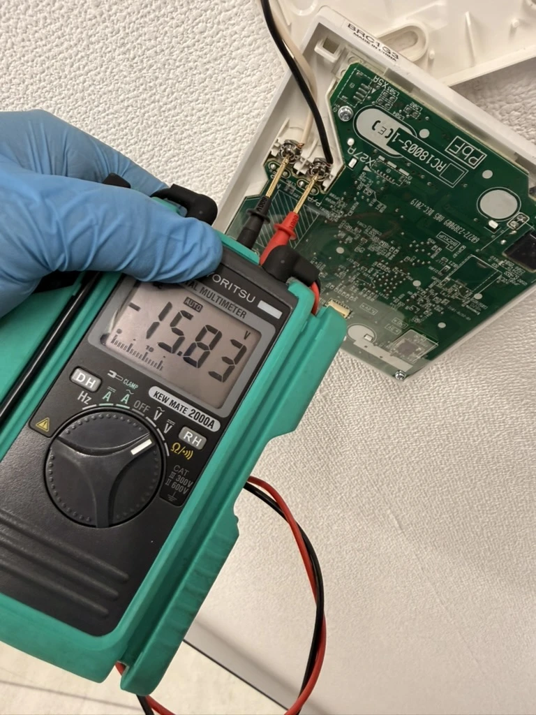 基板にテスターを当てて電圧を測定する不具合診断